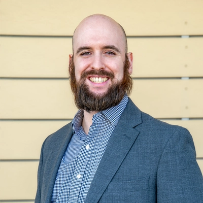 Transformational Life Coach Torrance CA Brian De Garmo 1 Brian De Garmo smiling in a suit.
