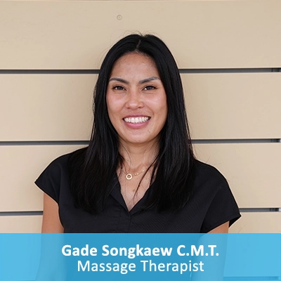 Massage Therapist Gade Songkaew In Front Of Wooden Wall With Caption