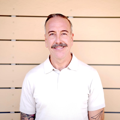 Chiropractor Gregory Stayberg In Front Of Wooden Wall